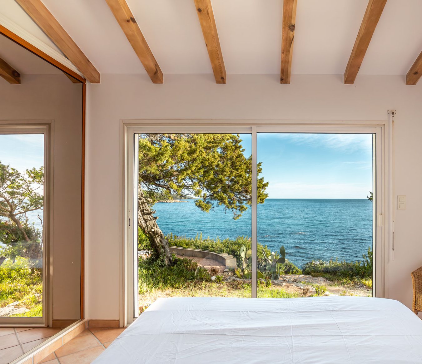 Schlafzimmer mit grosser Fensterfront zum Meer
