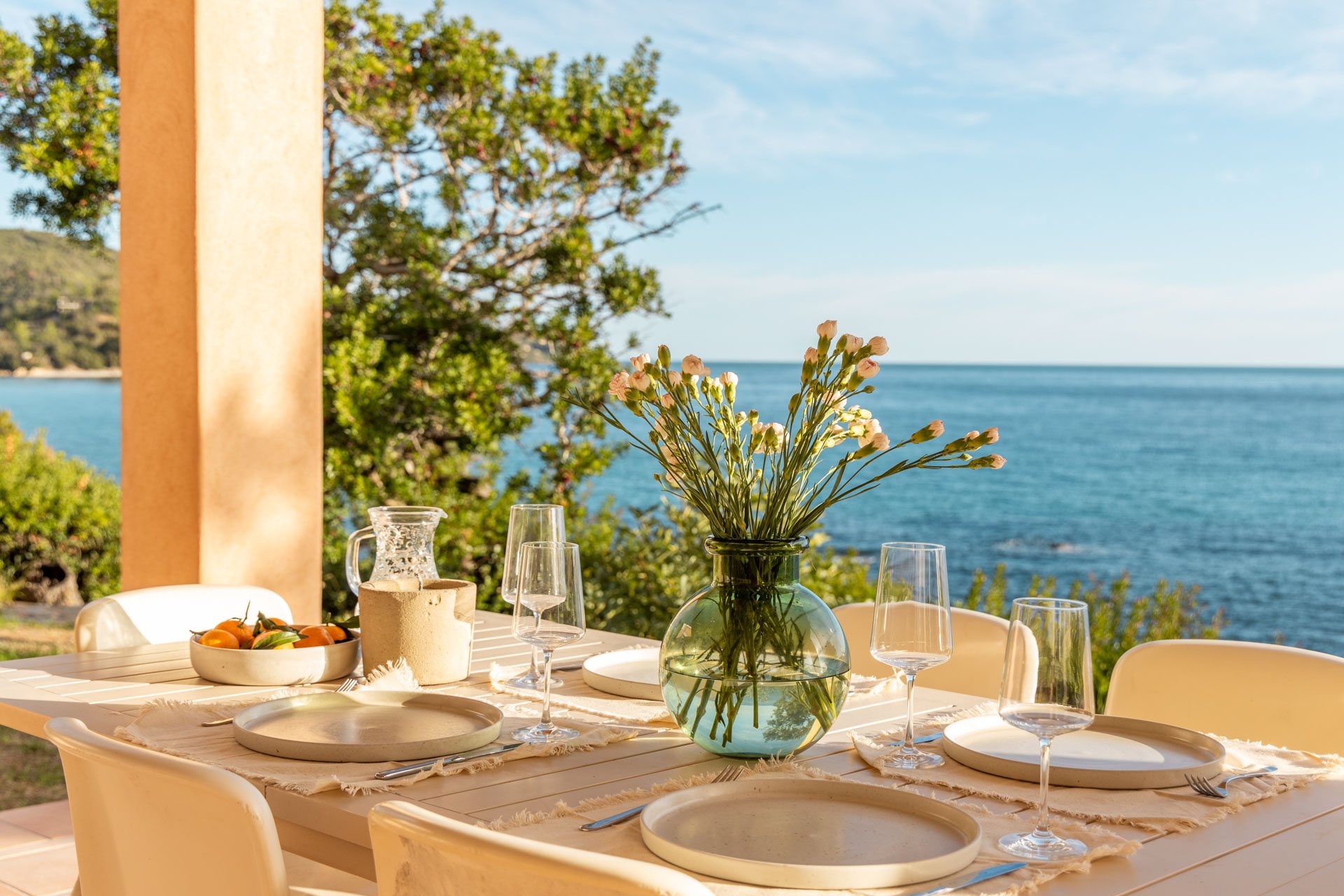 Gedeckter Tisch auf der Terrasse mit Blick aufs Meer